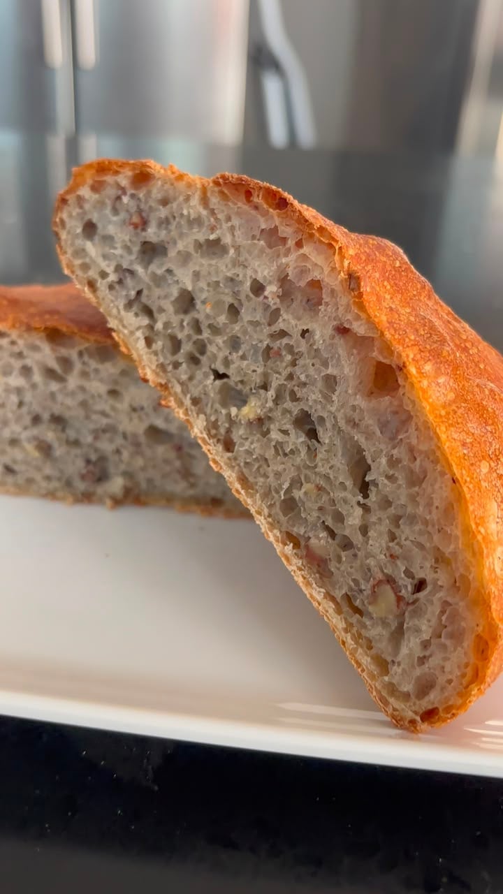 Corte de pan de masa madre con miga aireada y corteza dorada en plato blanco
